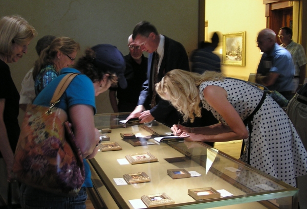 Wes and Rachelle Siegrist signing copies of their book, Exquisite Miniatures, at the R.W. Norton Art Gallery
